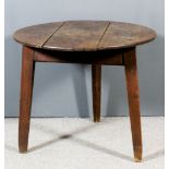 An 18th Century oak circular cricket table with three plank top, on three triangular splayed legs,