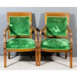 A pair of 19th Century French Empire mahogany armchairs with plain crest rails and dolphin scale