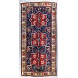 A Kazak Akstafa rug woven in colours with three bold eight-pointed stars filled with cross motifs,