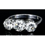 A silvery coloured metal mounted three stone diamond ring, set with three round brilliant cut