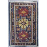 A Daghestan rug woven in colours with three bold stepped medallions filled with cross motifs on a