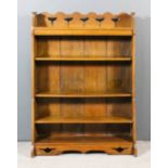 An early 20th Century oak open front bookcase of "Arts and Crafts" design with shaped and fretted