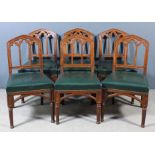 A set of six Victorian walnut dining chairs of Gothic design, the moulded backs with pointed