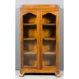 An early 20th Century oak display cabinet of small proportions, fitted three shelves enclosed by a