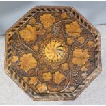 An unusual Victorian carved wood octagonal occasional table, the top carved with trailing fruiting
