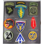 World War II US army patches, various divisions/regiments, contained in one album and two frames,