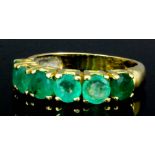 A 14ct gold mounted six stone emerald ring, claw set with five emeralds (each approximately .30ct)