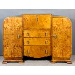 A 1930's figured walnut cocktail cabinet of "Art Deco" design, the central lifting lid and fall