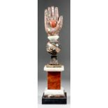 A mixed polished carved stone hand and heart sculpture on square stepped base, 16ins high