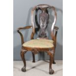 An 18th Century Continental walnut armchair with shaped back, fretted and carved vase pattern