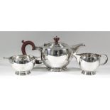 A George V silver circular three-piece tea service of Art Deco design of bulbous form, with scroll