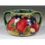 An early 20th Century Moorcroft pottery two-handled vase of squat form, tube lined with "