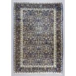 A Tabriz rug woven in muted colours, the repeating design of urns of flowers and floral ornament, on
