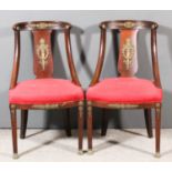 A pair of 19th Century French mahogany and gilt brass mounted chairs of Empire design, the crest