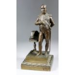 A brown patinated bronze standing figure of the Emperor Napoleon, a tripod table with his hat and