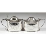 Two George III silver oval mustard pots, each with reeded mounts and domed covers, one engraved with