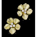 A pair of 18ct gold mounted and diamond flowerhead earrings (for pierced ears), each set with
