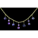 An Edwardian gold coloured metal fine chain necklace, hung with drops set with ten amethysts (