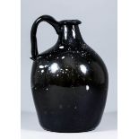 An early 19th Century Nailsea-type glass jug of olive tint with white flecks, 9ins high