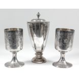 A pair of George III silver cylindrical goblets engraved with crest and leaf scroll ornament, on
