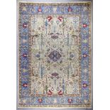 An antique Tabriz carpet woven in colours with a central lozenge shaped medallion and a field filled