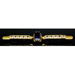 A gold coloured metal mounted sapphire and diamond bar brooch, with a central pale cornflower blue