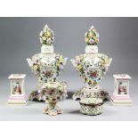 A pair of early 20th Century Continental porcelain two-handled flower encrusted vases and covers,