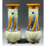 A pair of early 20th Century Royal Doulton stoneware vases painted in enamel colours with stylised