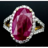 An 18ct gold mounted ruby and diamond ring, set with central oval facet cut ruby (approximately 7.