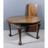 An early 20th Century mahogany circular extending dining table with three extra leaves with