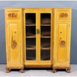 A Chinese panelled limed teak breakfront display cabinet with moulded edge to top, fitted three