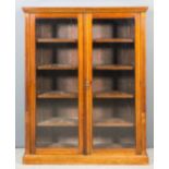 A late Victorian walnut bookcase with moulded cornice, fitted four shelves enclosed by a pair of