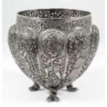 An Indian silvery metal circular bowl of lobed and tapered form, pierced with various figures and
