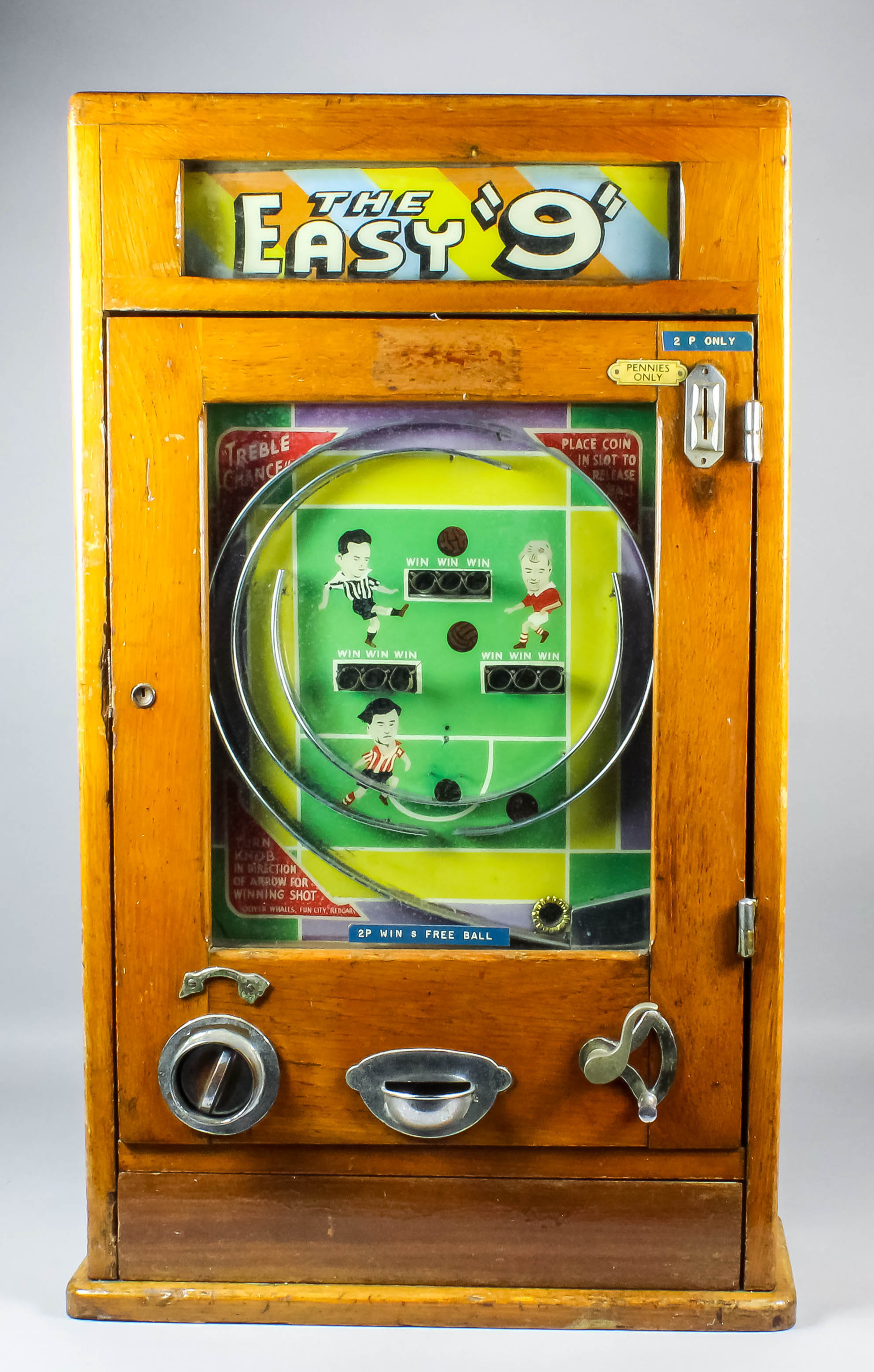 A 1950's oak cased Oliver Whales "Easy 9""Penny-in-the-Slot" Allwin with football themed face and "