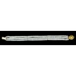 A modern three strand cultured pearl bead bracelet with 18ct gold circular pierced clasp, 180mm