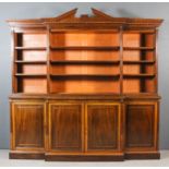 A late Victorian mahogany breakfront bookcase, the open upper part with deep moulded and angled