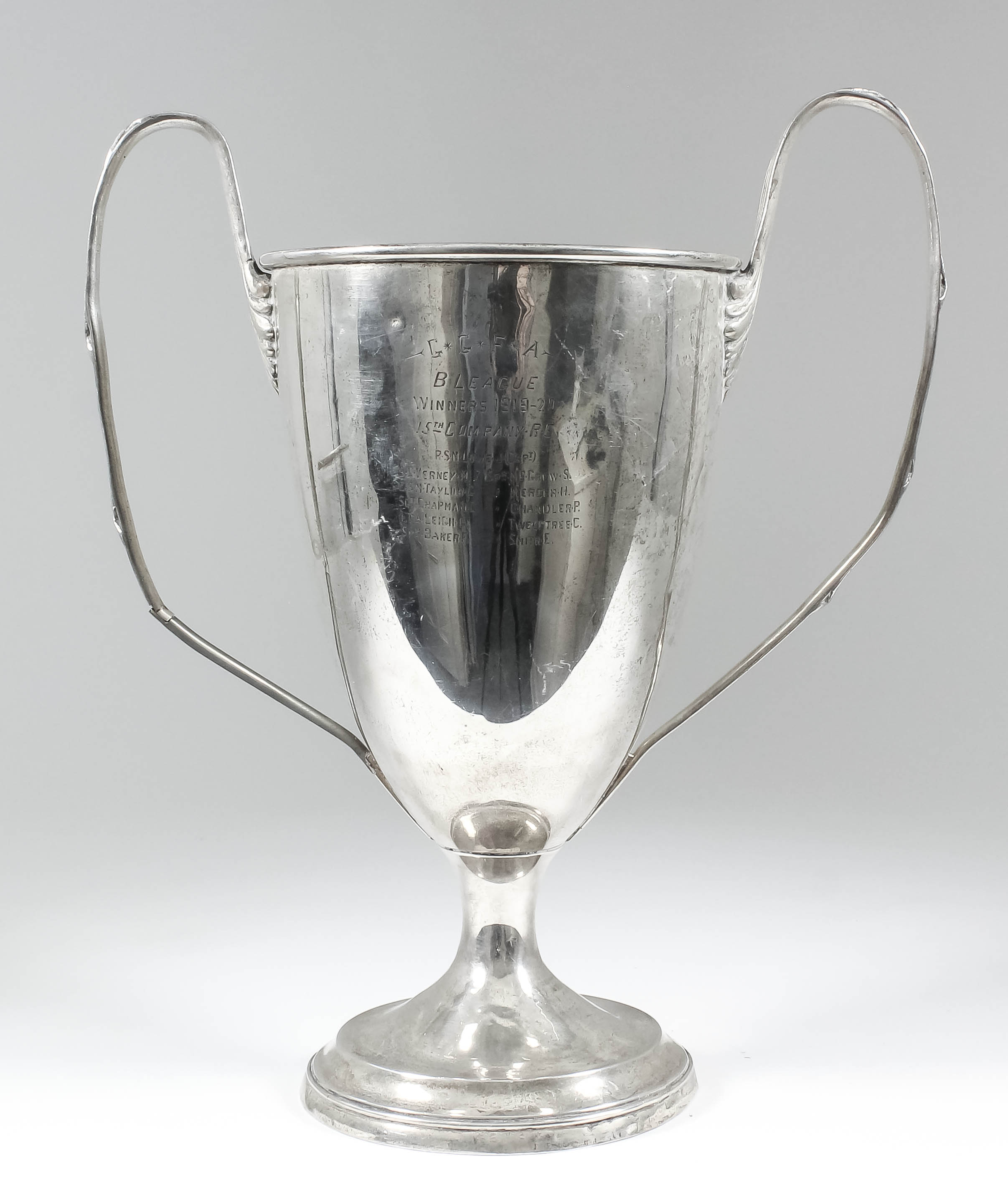 "G. G. F. A. B-League" - A George V silver two-handled cup with moulded rim, reeded and ribbon