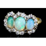 An 18ct gold mounted opal and diamond ring, set with three oval opals (approximate total weight 1.