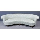 A late Victorian Howard & Sons crescent shaped scroll back settee upholstered in green and cream