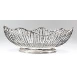 A George V silver oval cake basket with shaped rim and open reeded wirework frame, on oval reeded