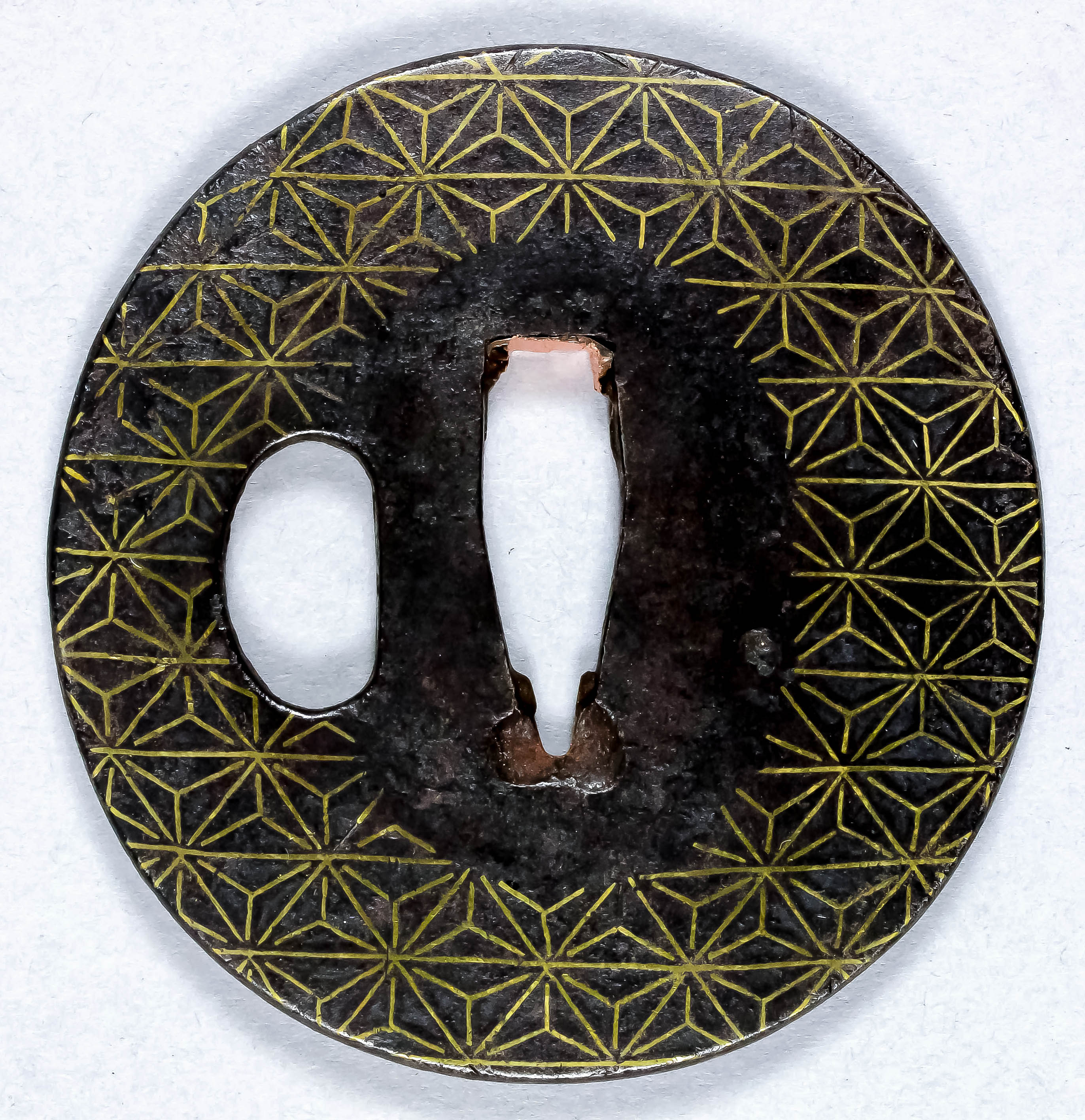 A Japanese Sendai school iron tsuba with diaper design inlaid in gold wire, Edo period, 2.75ins (