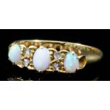 An 18ct gold mounted three stone opal ring, set with three oval opals interspersed by white