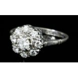 A modern platinum mounted and all diamond ring of flowerhead pattern, set with central round