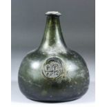 An early 18th Century glass sealed green glass onion shaped wine bottle of olive tint, the seal with
