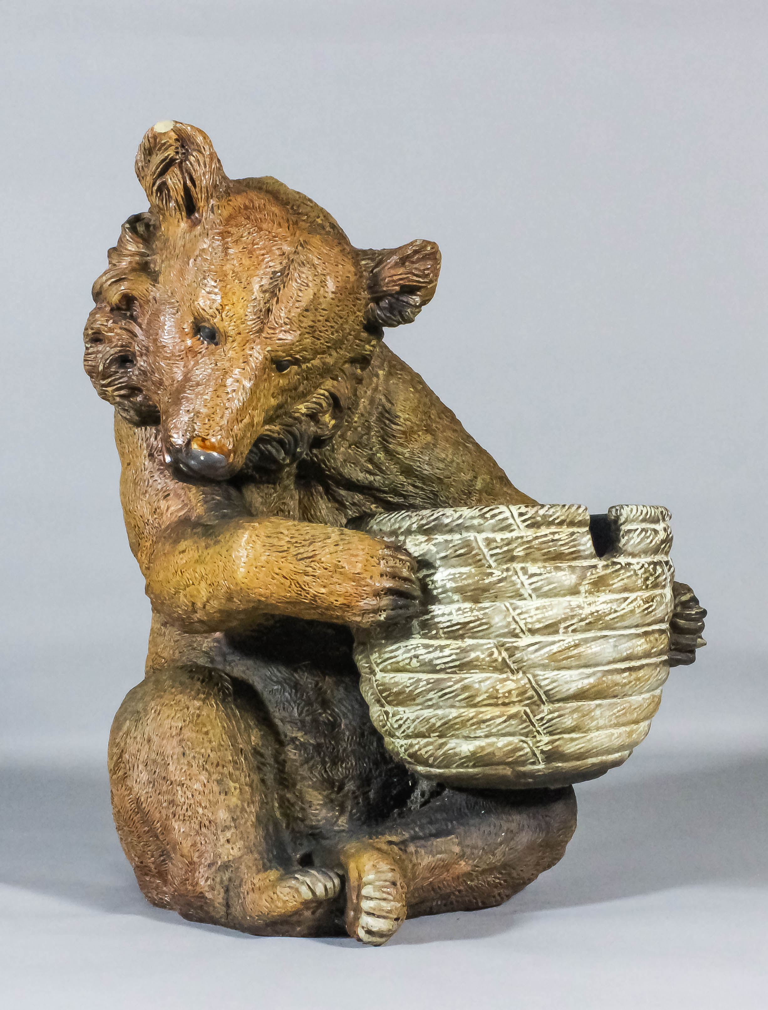 A good Doulton Lambeth salt glazed stoneware figure of a seated brown bear holding an upturned bee