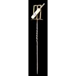 A late Victorian gold coloured metal stick pin of cricketing interest modelled in the form of a