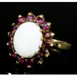 A modern 9ct gold mounted opal and red spinel ring, set with central oval opal, 10mm x 8mm,