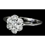 A modern 18ct white gold mounted seven stone diamond ring of flowerhead pattern, set with round