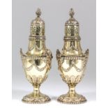 A pair of Edward VII silver gilt sugar casters, the urn pattern bodies with leaf capped, domed and