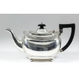An Edward VII silver rectangular teapot with reeded rim, ebonised finial and angular handle, on four